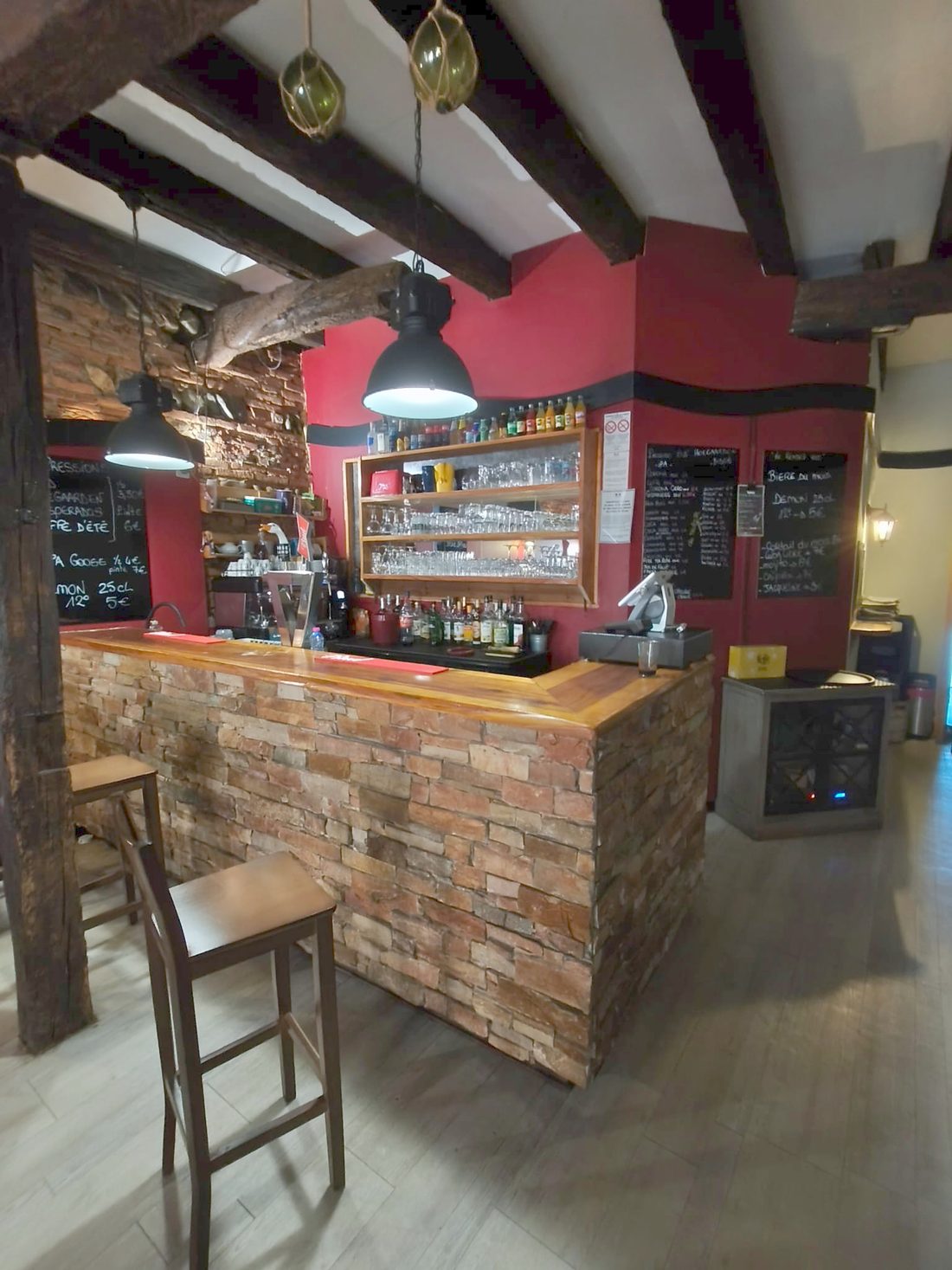 Le comptoir du Rendez-vous à Muret, mur rouge, pierre apparente et poutres