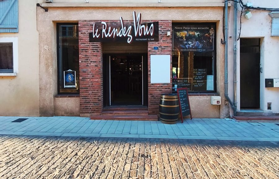 La façade du Rendez-vous sur la rue pavée du centre de Muret