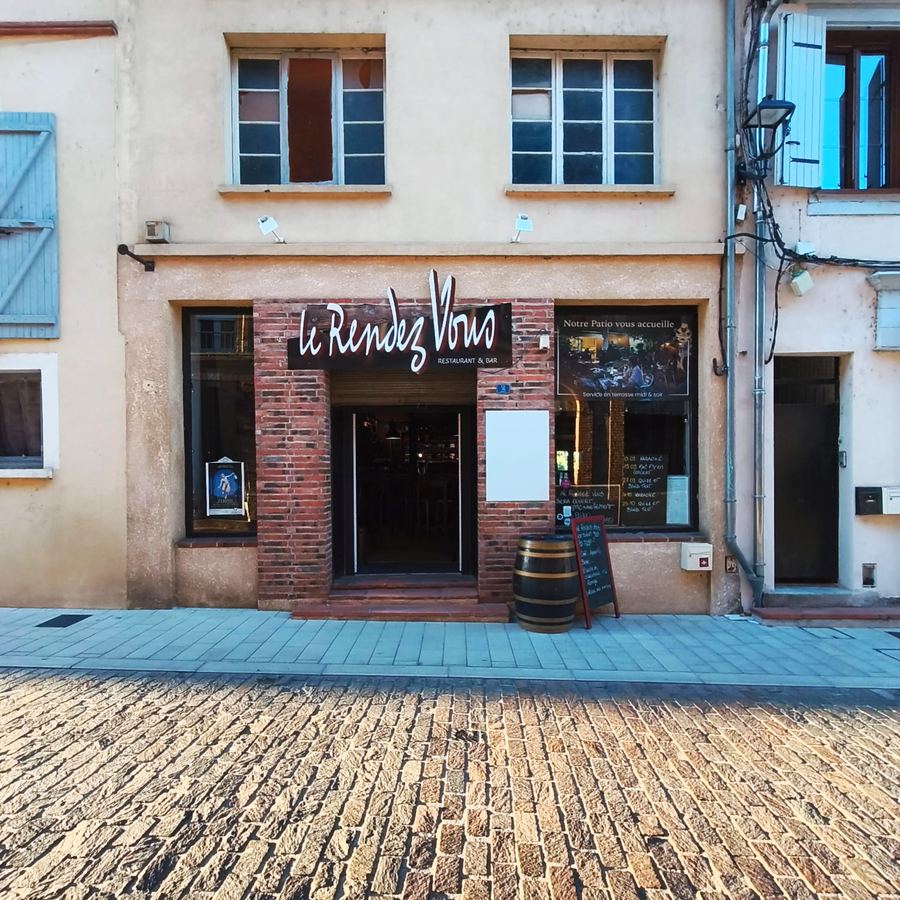 La façade du Rendez-vous sur la rue pavée de Muret