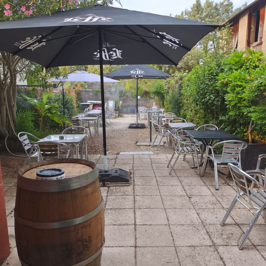 Le patio du Rendez-vous et son tonneau, sous les parasols